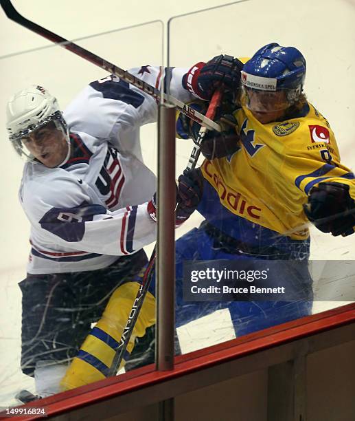 Cole Bardreau of the USA White Squad hits Linus Arnesson of Team Sweden at the USA hockey junior evaluation camp at the Lake Placid Olympic Center on...