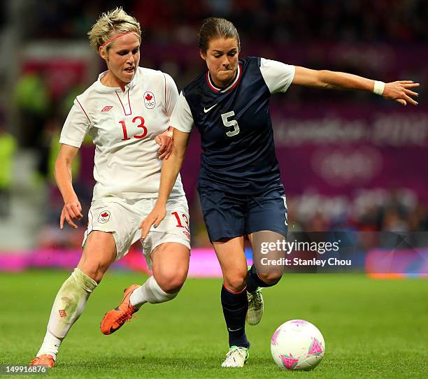 Kelley O'Hara of the United States competes with Sophie Schmidt of Canada during extra time during the Women's Football Semi Final match between...