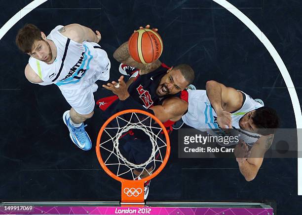 Tyson Chandler of United States goes to the hoop against Andres Nocioni and Carlos Delfino of Argentina during the Men's Basketball Preliminary Round...