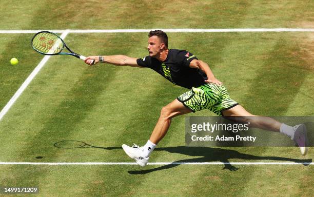 Marton Fucsovics of Hungary stretches for a forehand volley during his match against Frances Tiafoe of the United States in the semi-final match on...