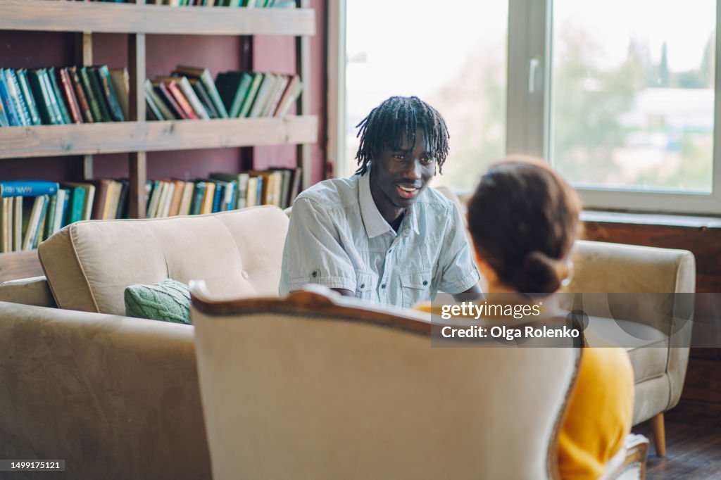 Unrecognised counselor listens to a male patient in the office
