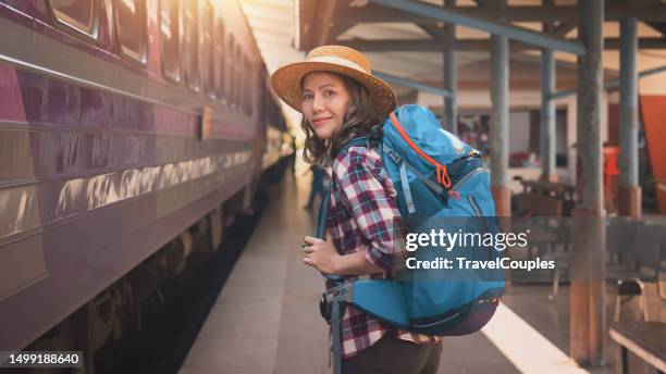 woman traveler tourist walking at train station. young asian woman traveler with backpack in the railway. backpack and hat at the train station with a traveler. travel concept. - ankommen stock-fotos und bilder