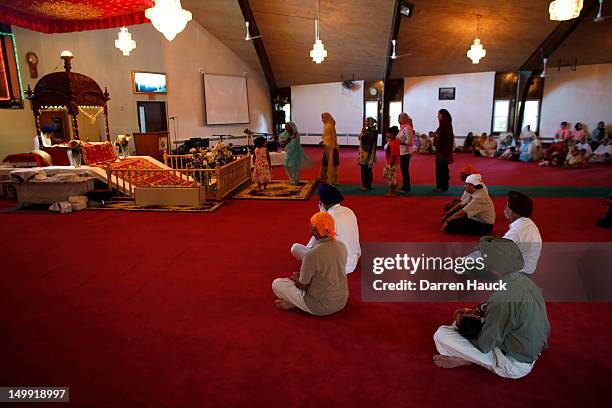 Members of the Sikh community along with other mourners attend a special service at the Sikh Religious Society of Wisconsin for the victims of the...