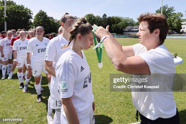 Elfie Wuttke, Board of Girls and Women's Football and hand sout the silver medals to the team of Aurich on the podium after the B-Junior Girls Final...