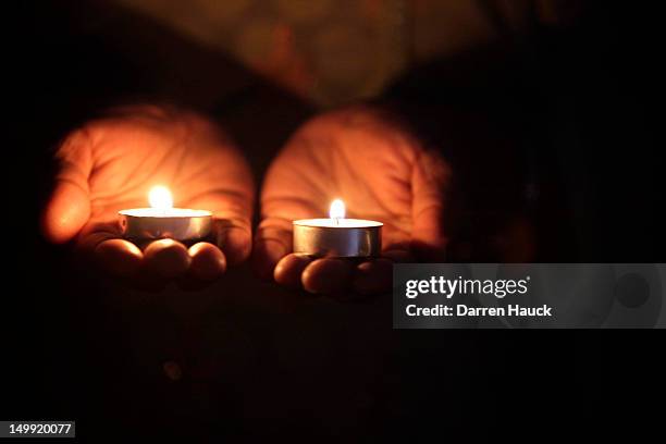 Mourner holds two candles during a vigil at the Sikh Religious Society of Wisconsin for the victims of the shooting at the Sikh Temple of Wisconsin...