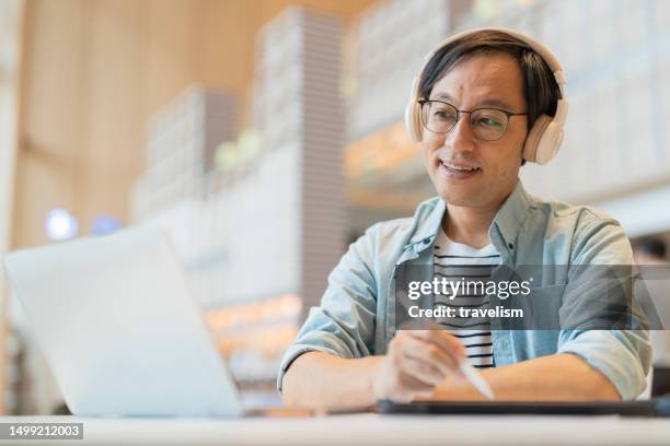 smart confidence asian startup entrepreneur business owner businessman smile using laptop working online while listening music wireless headphone working relax leisure in cafe - korea technology stock pictures, royalty-free photos & images
