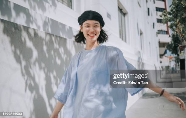 portrait young asian chinese woman on pedestrian walkway looking at camera - street fashion asian stock pictures, royalty-free photos & images