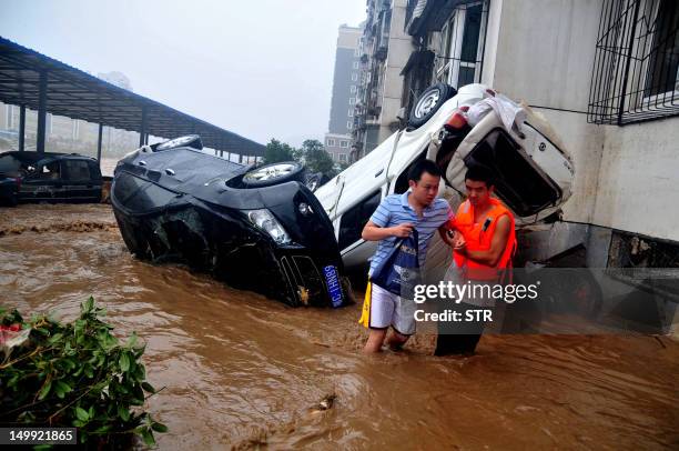 This picture taken on August 6, 2012 shows damaged cars by the side of a street, after a storm following Typhoon Saola hits Shiyan, in central...