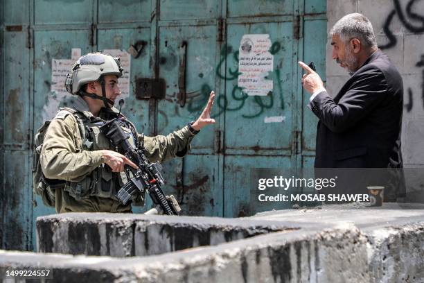 Palestinian man argues with an Israeli soldier in the centre of Hebron in the occupied West Bank on July 4, 2023. Israel's biggest military operation...