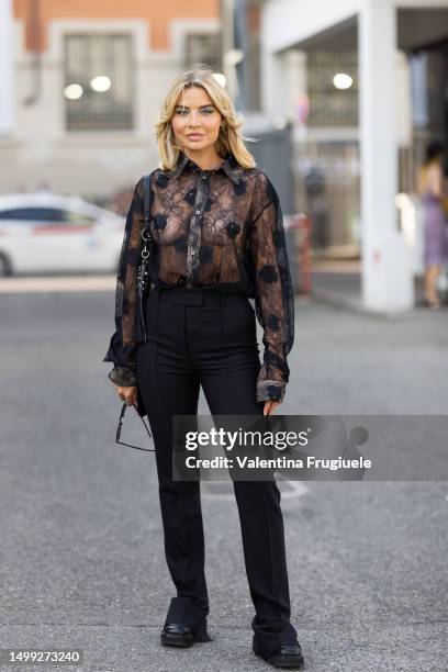 Veronica Ferraro is seen wearing a black see-thought lace long sleeves shirt, black hight waist trousers, black sunglasses, black leather shoes and a...