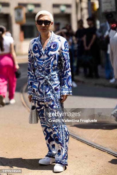 Bryanboy is seen wearing a Dolce & Gabbana light blue and white printed matching set made of a jacket and wide leg trousers, a white leather bag and...