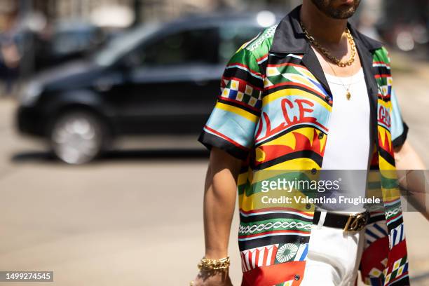 Guest is seen wearing gold necklaces, gold bracelets, a white tank top, a Dolce & Gabbana multicolor printed short sleeves shirt, a black Dolce &...
