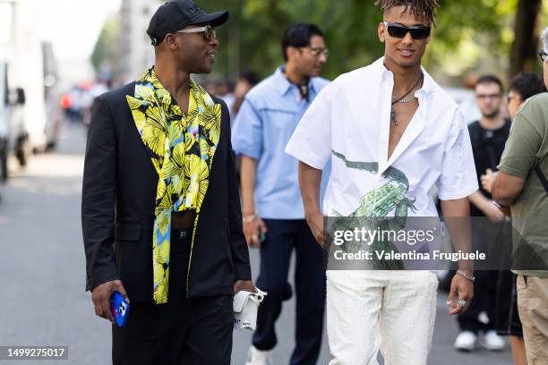 Caption MILAN, ITALY Guests are seen wearing on the left a black hat, light brown sunglasses, a multicolor printed cropped shirt woth the matching...