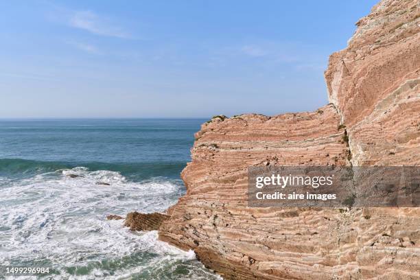 side view of rock formation on the cliffs of a beach in zumaia with the sea in the background. - cliff texture stockfoto's en -beelden