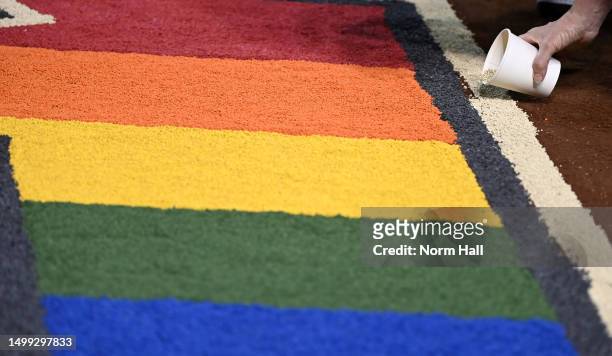 Arizona Diamondbacks grounds crew and staff members use colored sand to decorate the team logo in conjunction with Pride Night at Chase Field during...