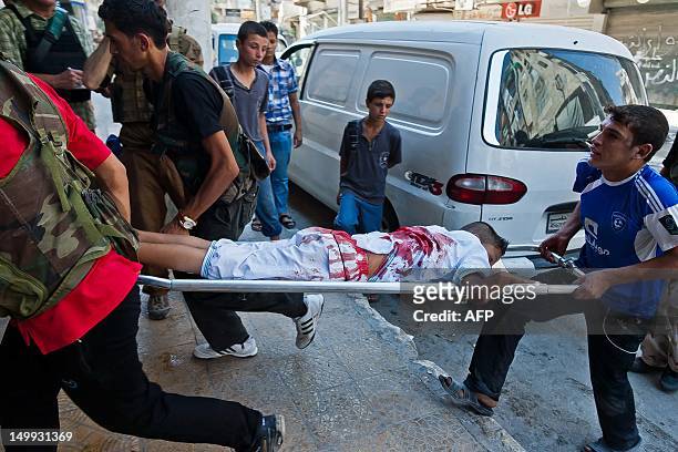 Wounded Syrian youth is carried on a stretcher after he was injured during clashes between rebel fighters and Syrian government forces in the...