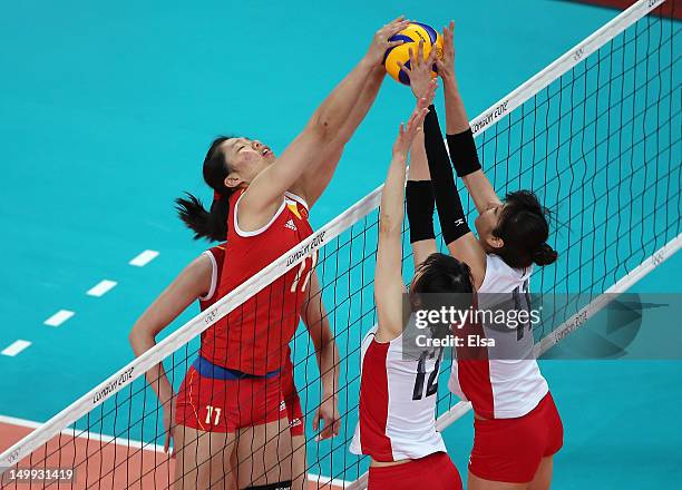 Yunli Xu of China tries to get the ball past Ai Otomo and Risa Shinnabe of Japan during Women's Volleyball on Day 11 of the London 2012 Olympic Games...