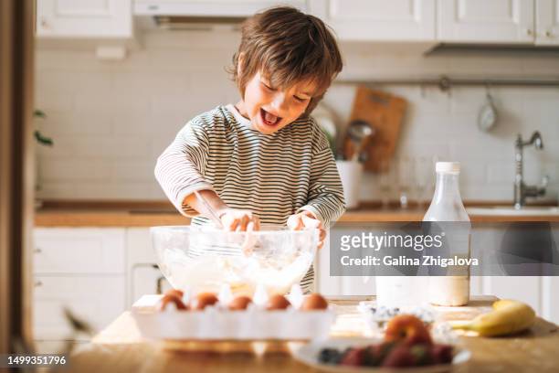cute small child boy 4-5 years cooking with flour knead dough in kitchen at home - 4 5 years stock pictures, royalty-free photos & images