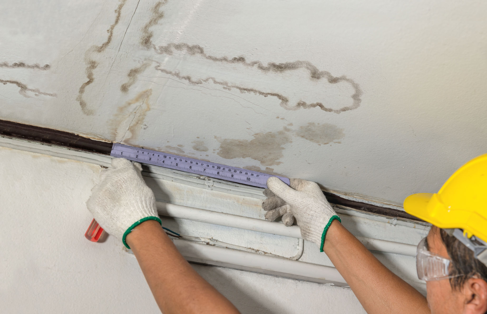 Worker fix leaking pipe in ceiling ,close-up of a stain on the ceiling. Worker fix leaking pipe in ceiling ,close-up of a stain on the ceiling.