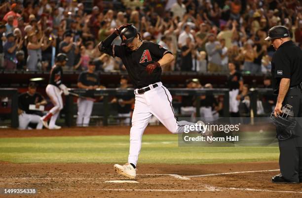 Jake McCarthy of the Arizona Diamondbacks crosses home plate after hitting a solo home run against the Cleveland Guardians during the eighth inning...