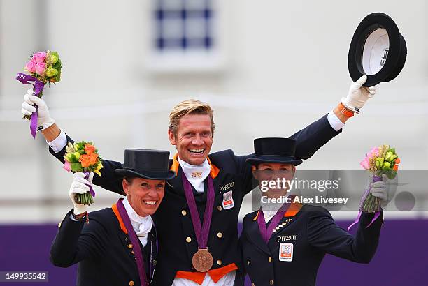 Bronze medalists Anky Van Grunsven, Edward Gal and Adelinde Cornelissen of Netherlands celebrate with their medals during the medal cerermony for the...