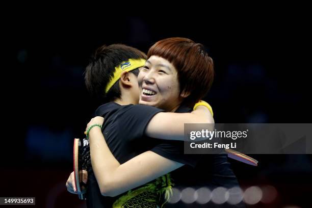 Yue Guo and Xiaoxia Li of China celebrate their 3-1 victory against Kasumi Ishikawa and Sayaka Hirano of Japan and winning the Women's Team Table...