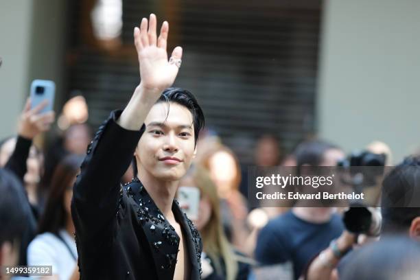 Doyoung wears a black with embroidered large stones / sequins pattern asymmetric blazer jacket , outside Dolce & Gabbana, during the Milan Fashion...