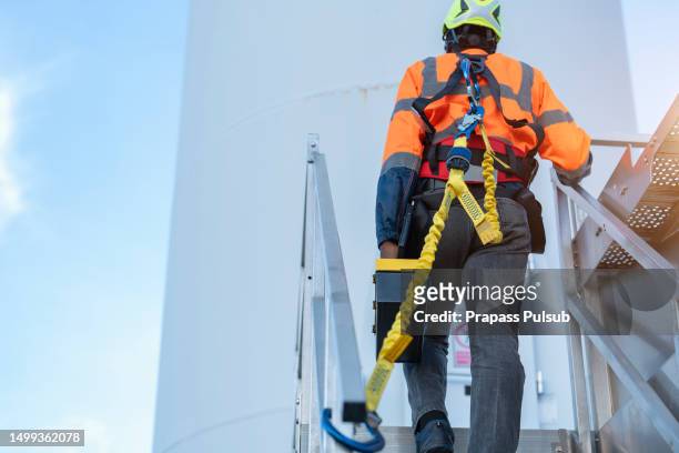 worker wearing safety harness and safety line working at high place - arbeitskleidung stock-fotos und bilder