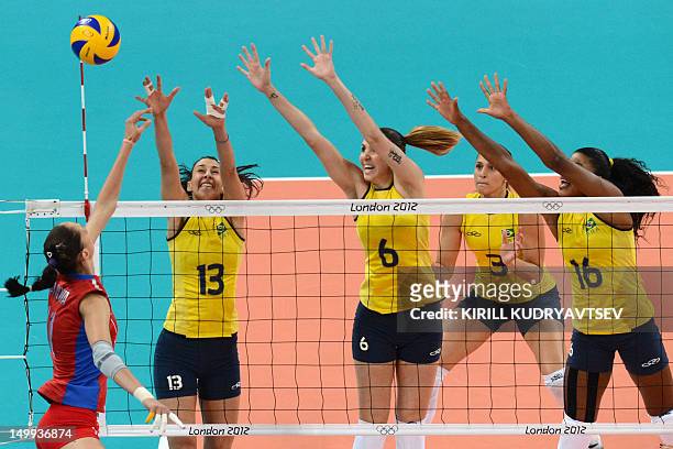 Russia's Ekaterina Gamova spikes as Brazil's Fernanda Rodrigues , Thaisa Menezes and Sheilla Castro attempt to block during the Women's quarterfinal...