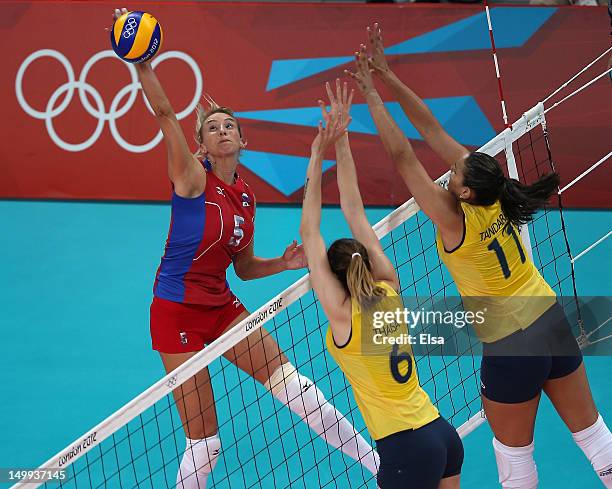 Liubov Shashkova of Russia spikes the ball as Thaisa Menezes and Tandara Caixeta of Brazil defend during Women's Volleyball on Day 11 of the London...