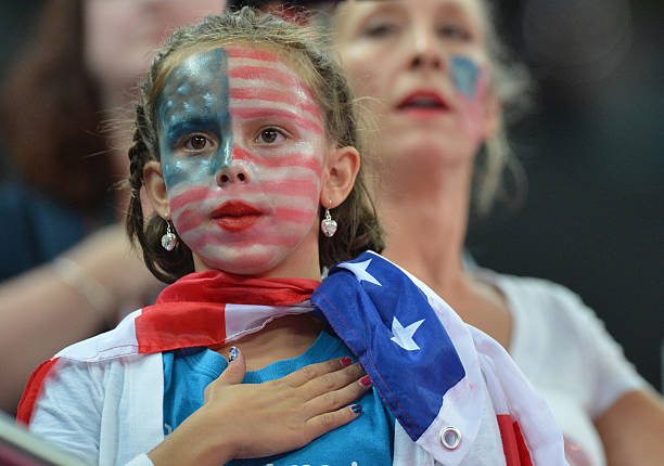 Young US supporter liestens to the national anthems after the women' s floor exercise final of the artistic gymnastics event of the London Olympic...
