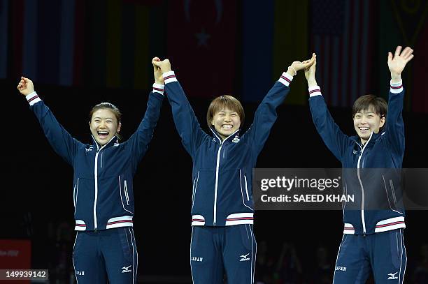 Silver medallists Japan's Ai Fukuhara, Sayaka Hirano and Kasumi Ishikawa celebrate on the podium after the table tennis women's team finals of the...