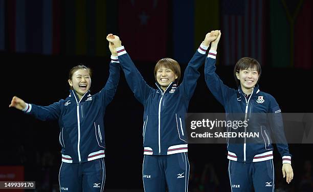 Silver medallists Japan's Ai Fukuhara, Sayaka Hirano and Kasumi Ishikawa celebrate on the podium after the table tennis women's team finals of the...