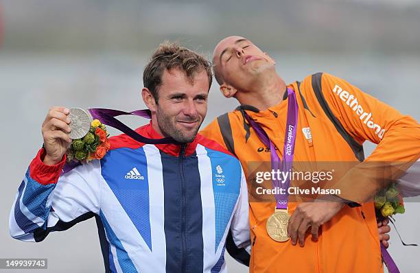 Gold medallist Dorian Van Rijsselberge of Netherlands celebrates with silver medallist Nick Dempsey of Great Britain following the Men's RS:X Sailing...