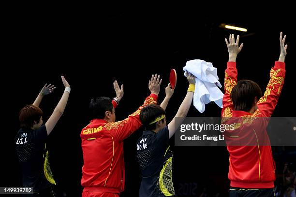 Xiaoxia Li , Yue Guo and Ning Ding of China and head coach Shi Zhihao celebrate defeating Japan to win the Women's Team Table Tennis gold medal match...