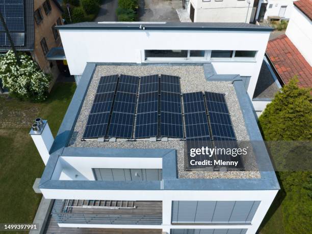 photovoltaic solar panels on modern home sustainable energy carbon footprint - plat dak stockfoto's en -beelden