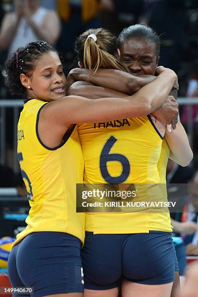 Brazil's players gather around teammate Thaisa Menezes as they celebrate Brazil's victory in the Women's quarterfinal volleyball match between Russia...