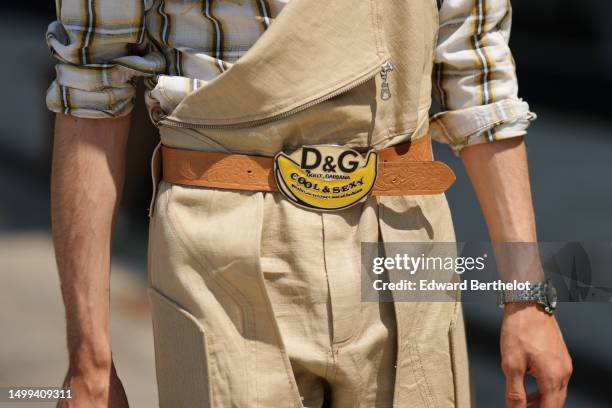 Guest wears a beige with black and yellow checkered print pattern cotton shirt, beige linen overalls, a beige shiny embossed pattern leather with...