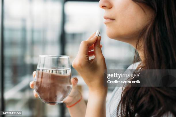 donna che prende la pillola per stare meglio - prendere-le-pillole foto e immagini stock