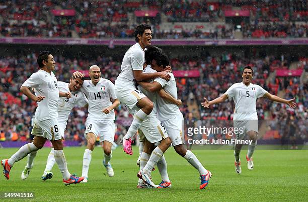 Javier Cortes of Mexico celebrates with team mates after scoring the third goal during the Men's Football Semi Final match between Mexico and Japan,...