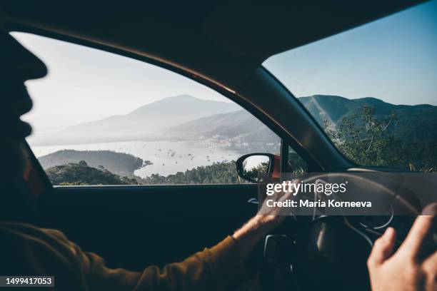 man driving a car near the sea. - modern driveway stock pictures, royalty-free photos & images