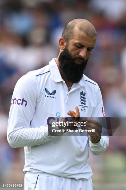 Moeen Ali of England looks at his finger after bowling during Day Three of the LV= Insurance Ashes 1st Test match between England and Australia at...