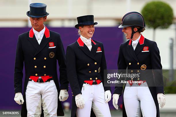 Carl Hester, Laura Bechtolsheimer and Charlotte Dujardin of Great Britain celebrate before receiving their gold medals during the medal cerermony for...