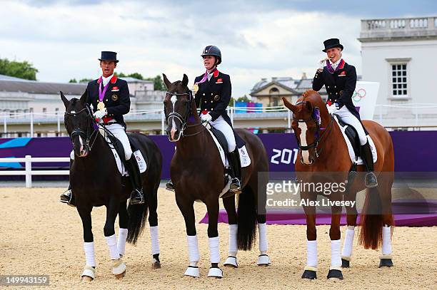 Carl Hester on Uthopia, Charlotte Dujardin of Great Britain on Valegro and Laura Bechtolsheimer on Mistral Hojris celebrate with their gold medals...