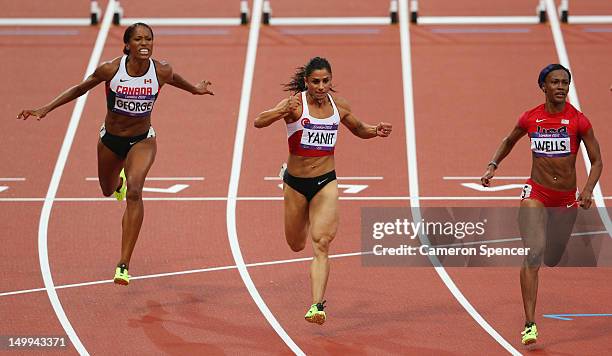 Kellie Wells of the United States leads Nevin Yanit of Turkey and Phylicia George of Canada competing in the Women's 100m Hurdles Semifinals on Day...