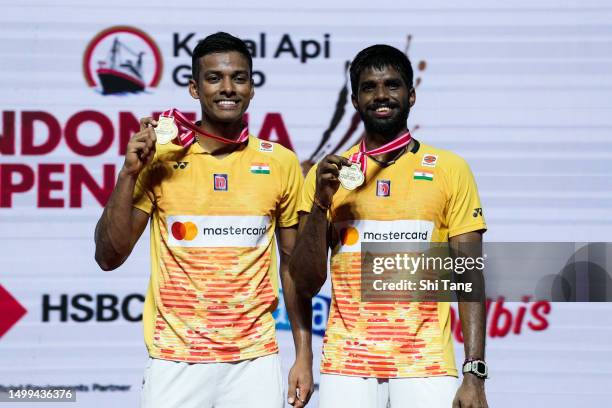 Satwiksairaj Rankireddy and Chirag Shetty of India pose with their trophies on the podium after the Men's Double Final match against Aaron Chia and...