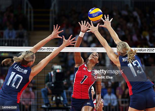 Annerys Victoria Vargas Valdez of the Dominican Republic spikes the ball as Jordan Larson and Christa Harmotto of the United States defend during...