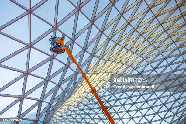 windows cleaner in a modern airport terminal - higher return stock pictures, royalty-free photos & images