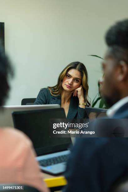 trabalhadora millennial frustrada sentada à mesa com colegas - problemas de comunicação - fotografias e filmes do acervo