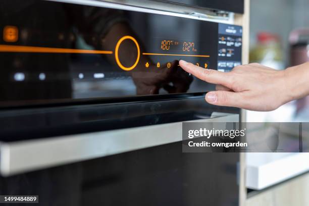 asian woman baking cookies in her kitchen - horno fotografías e imágenes de stock